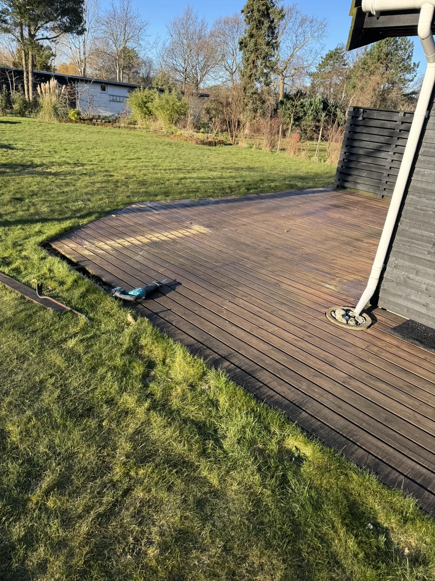 Den gamle terrasse ved sort træhus, før arbejdet