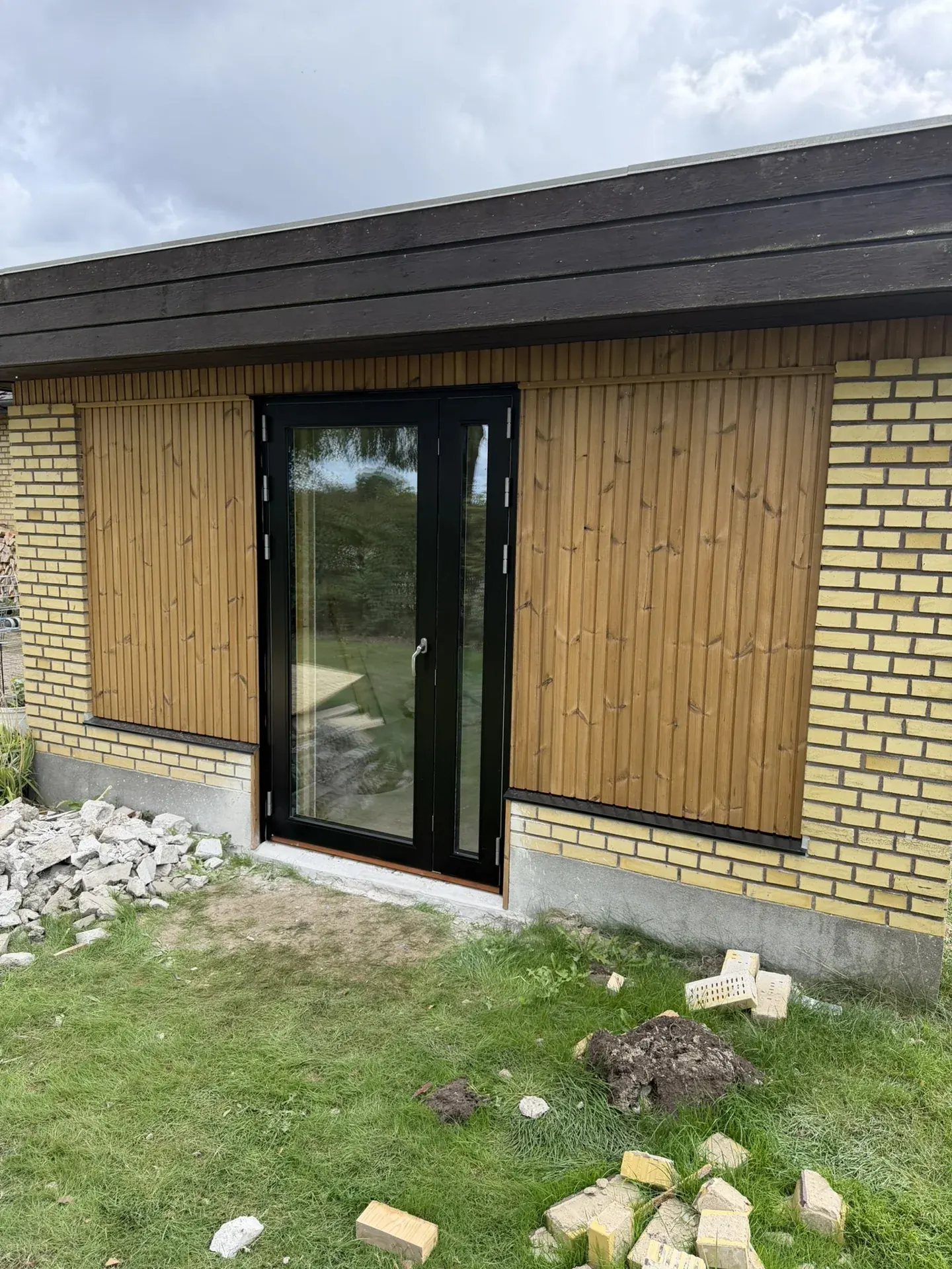 Træbeklædt facade med nye glasdøre