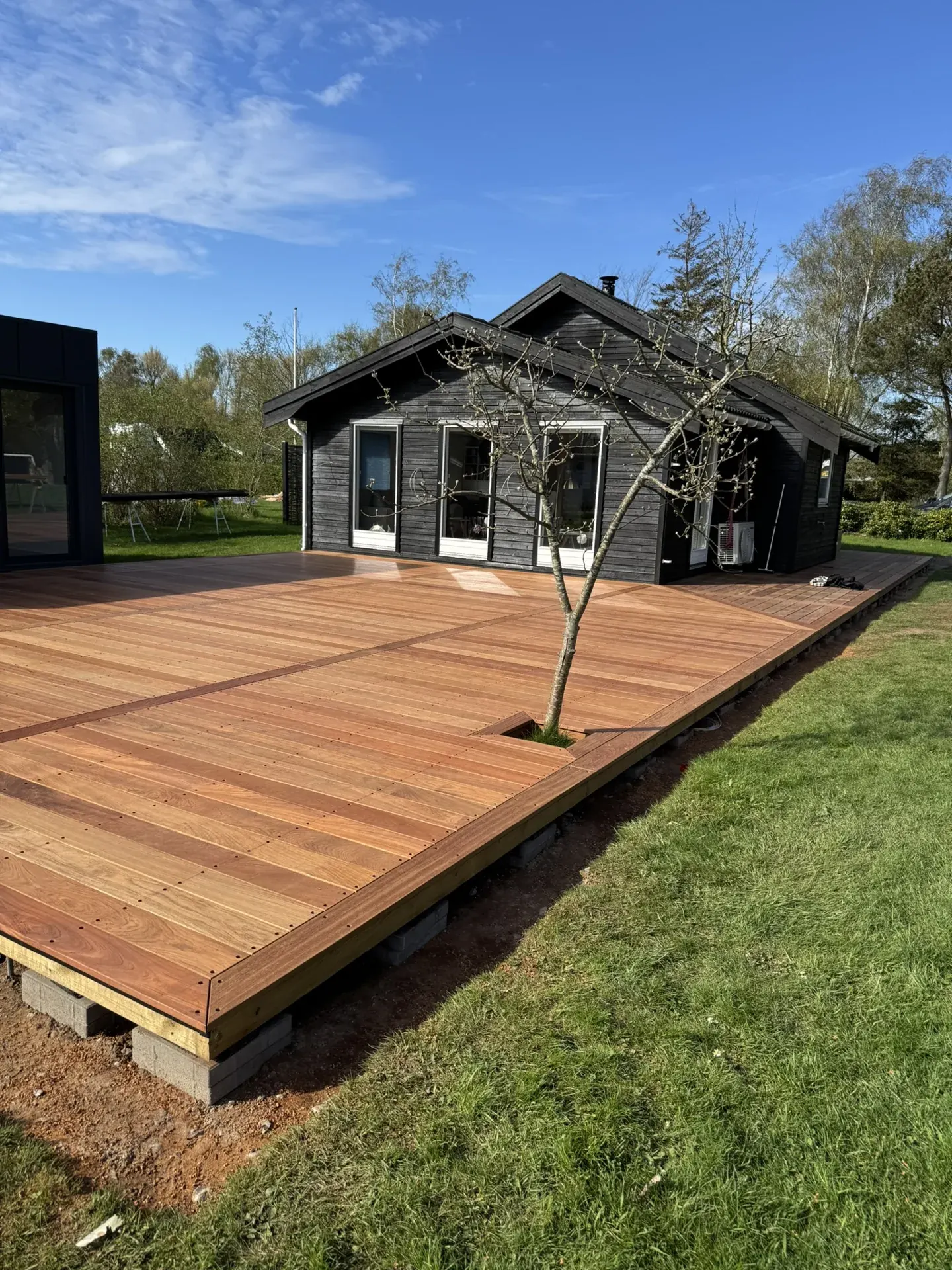 Ny stor træterrasse ved sort sommerhus