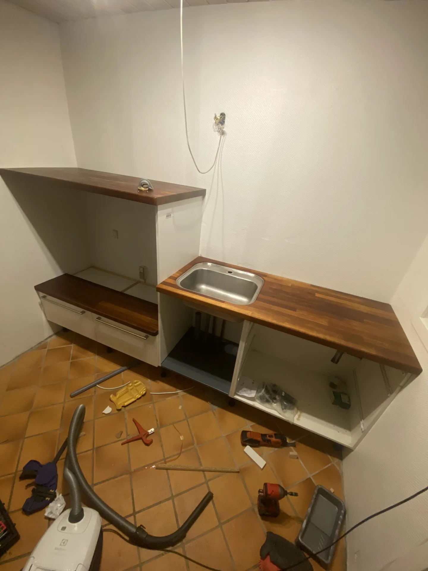 Bryggers under montering af skabe og bordplade